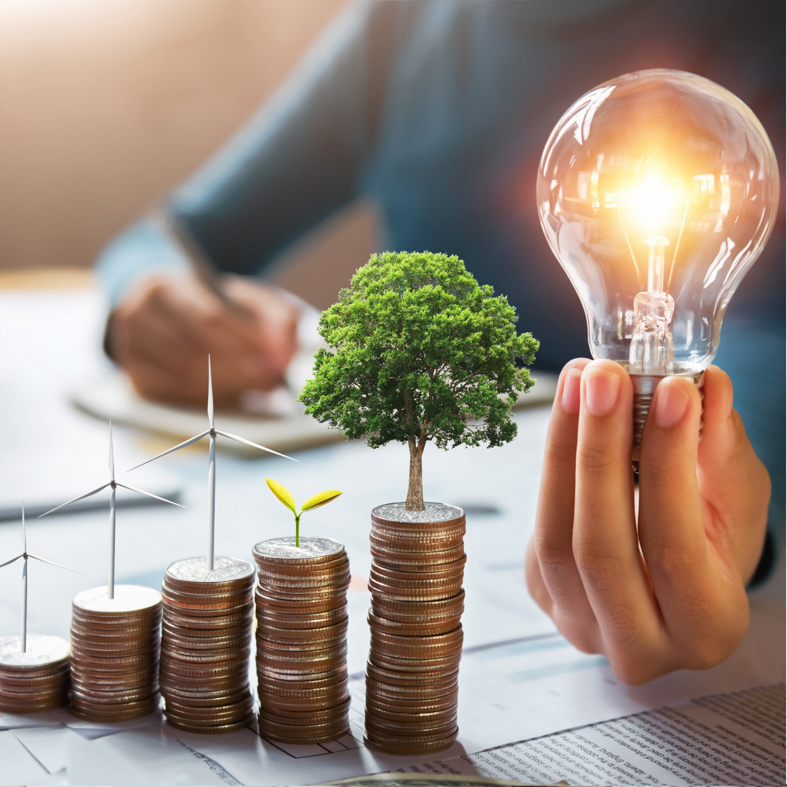 businessman holding lightbulb with turbine and tree grow on coin