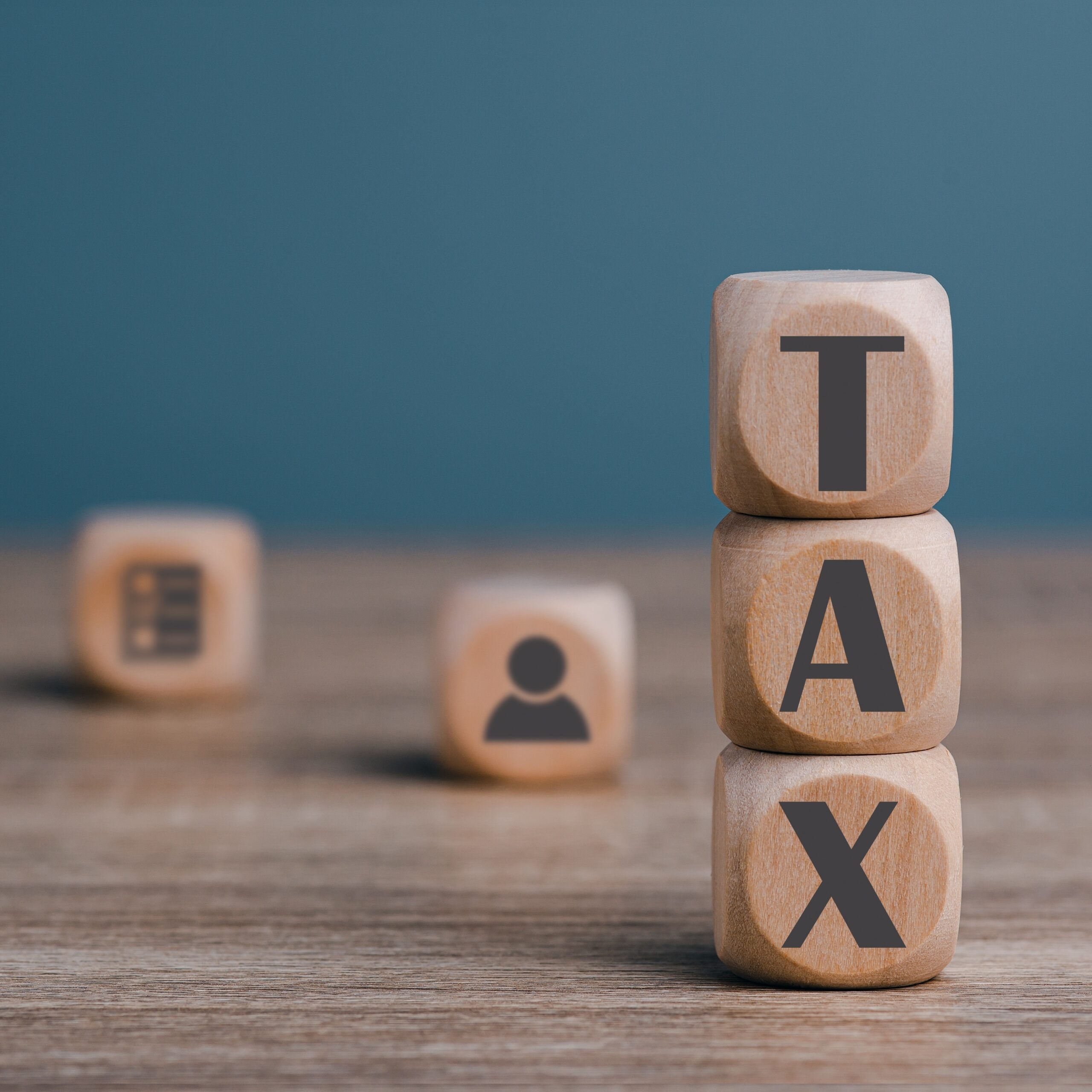 Stacked wooden blocks on the desk, income tax management concept